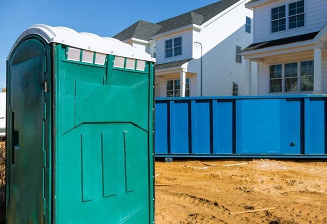 a row of blue and white portable toilets on a busy work site